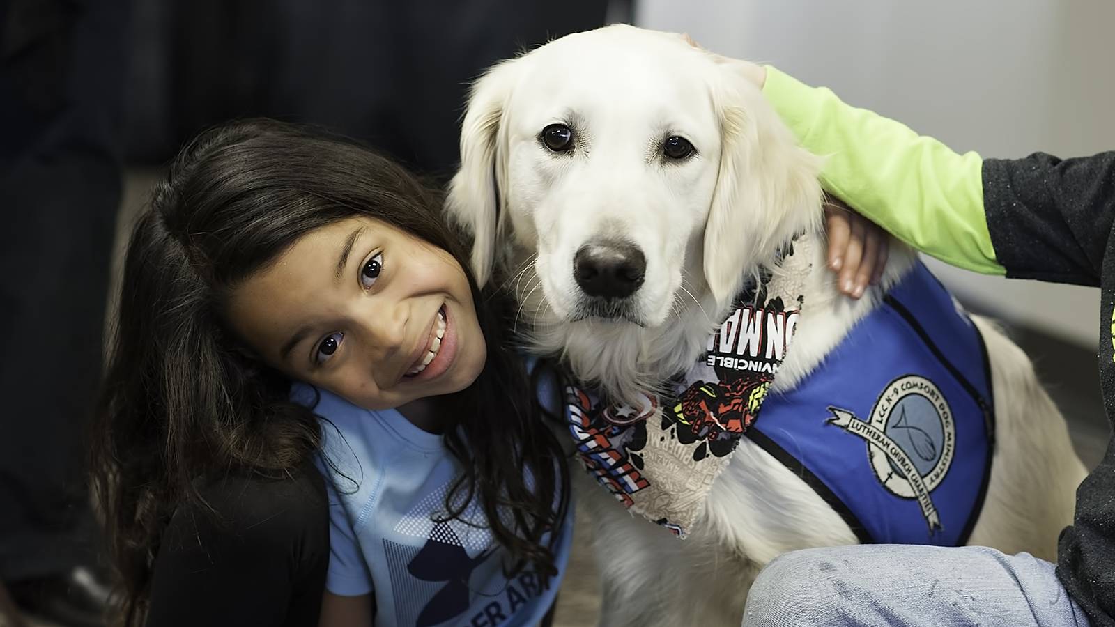 A girl hugs a service dog